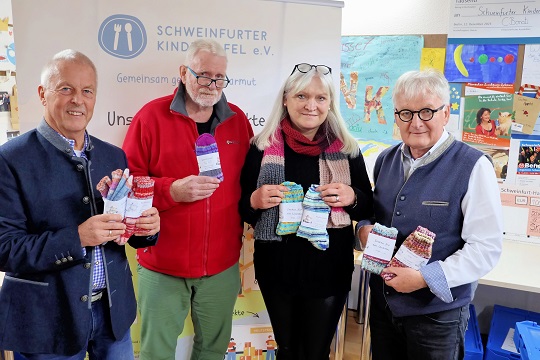 Ein Scheck und Selbstgestricktes: Der Gartenbauverein Obertheres und „Socken für ein Lächeln“ spendeten für die Kindertafel