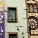 Banner neben dem Würzburger Kiliansdom wirbt für Menschenwürde, Nächstenliebe und Zusammenhalt