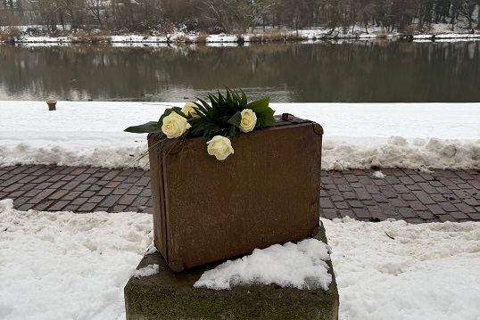 Blumen an der Gepäck-Skulptur am Mainkai niedergelegt: Marktheidenfeld gedenkt der Opfer der NS-Zeit